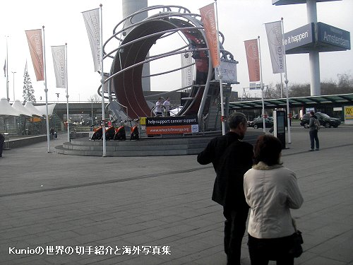オランダ・アムステルダムのスキポール空港前の風景　人間モルモット（大きな輪の中に入り輪を回転する寂しい遊び）