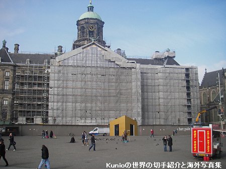 アムステルダムの中心街の王宮（現在修理中）とその前の広場の風景です。　雑踏と路面電車。